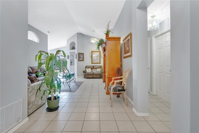 entrance foyer featuring light tile patterned floors, visible vents, ceiling fan with notable chandelier, and vaulted ceiling