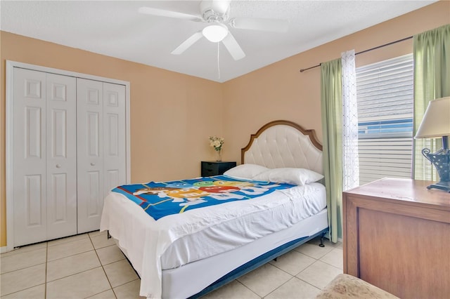 bedroom with light tile patterned floors, a closet, and ceiling fan