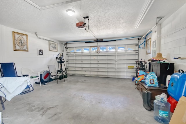 garage with concrete block wall and a garage door opener