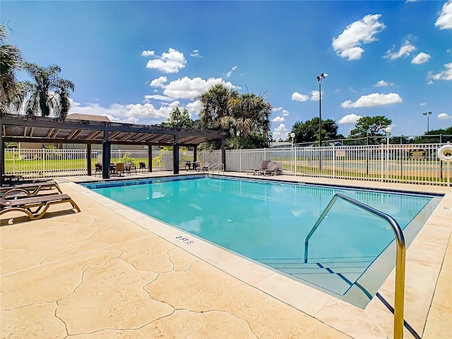 community pool with a patio and fence