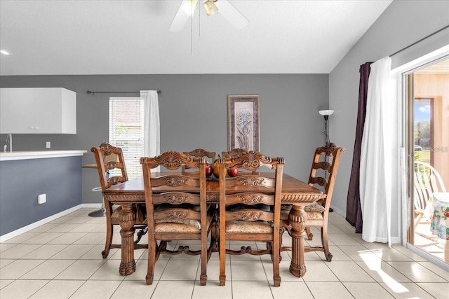 dining room with light tile patterned floors, baseboards, lofted ceiling, and a ceiling fan