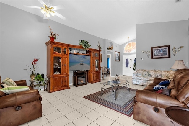 living area featuring light tile patterned flooring, a glass covered fireplace, a ceiling fan, and lofted ceiling