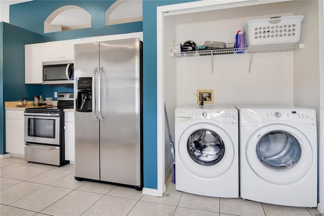 laundry area featuring washing machine and dryer, light tile patterned flooring, and laundry area