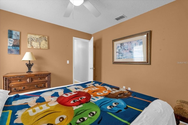 bedroom with visible vents, a textured ceiling, and a ceiling fan