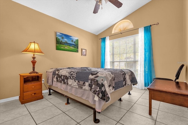 tiled bedroom with baseboards, a textured ceiling, a ceiling fan, and vaulted ceiling