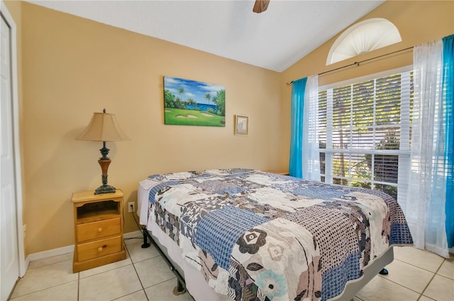 tiled bedroom with lofted ceiling, a ceiling fan, and baseboards