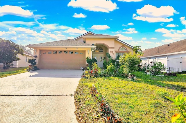 view of front of home with fence, a garage, driveway, and stucco siding