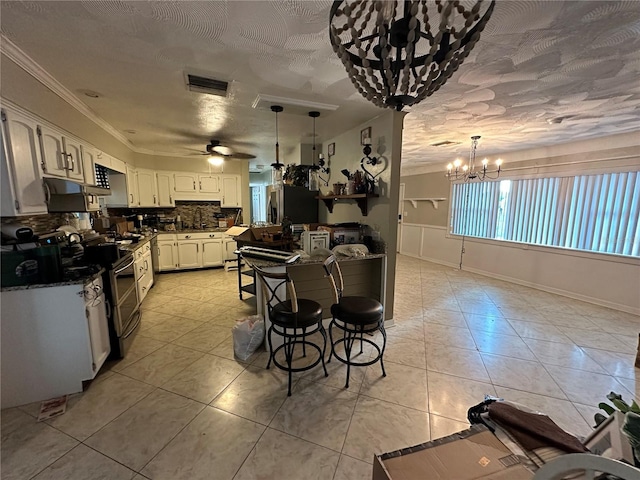 kitchen with dark countertops, visible vents, backsplash, ceiling fan with notable chandelier, and appliances with stainless steel finishes