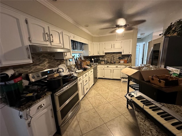 kitchen with under cabinet range hood, double oven range, light tile patterned flooring, white cabinets, and crown molding