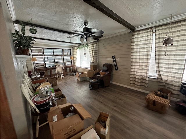 living room with ceiling fan, beam ceiling, a textured ceiling, and wood finished floors