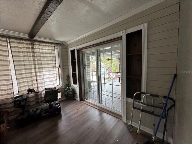 misc room featuring crown molding, wooden walls, wood finished floors, and a textured ceiling