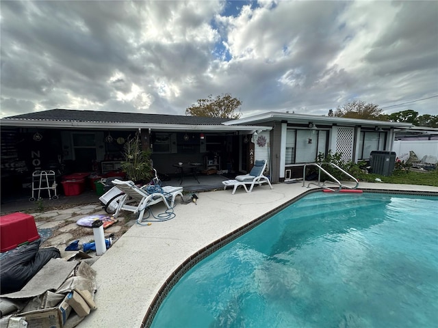 back of property with an outdoor pool and a patio area