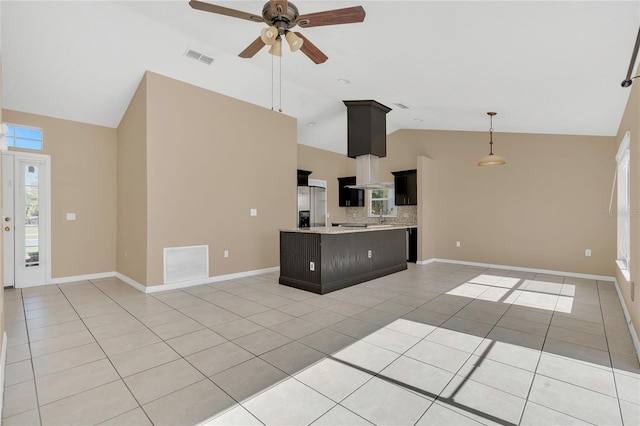 kitchen featuring visible vents, open floor plan, a center island, stainless steel fridge, and light tile patterned floors