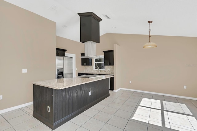 kitchen with light tile patterned floors, visible vents, stainless steel fridge, and dark cabinetry