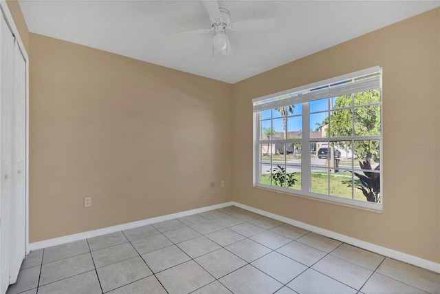 empty room with plenty of natural light, baseboards, and light tile patterned floors