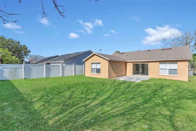 back of house featuring a lawn, fence, and stucco siding