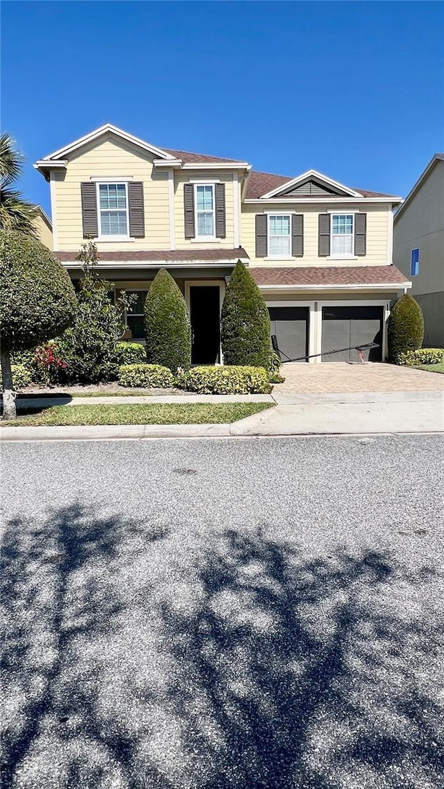 view of front of home with an attached garage and decorative driveway