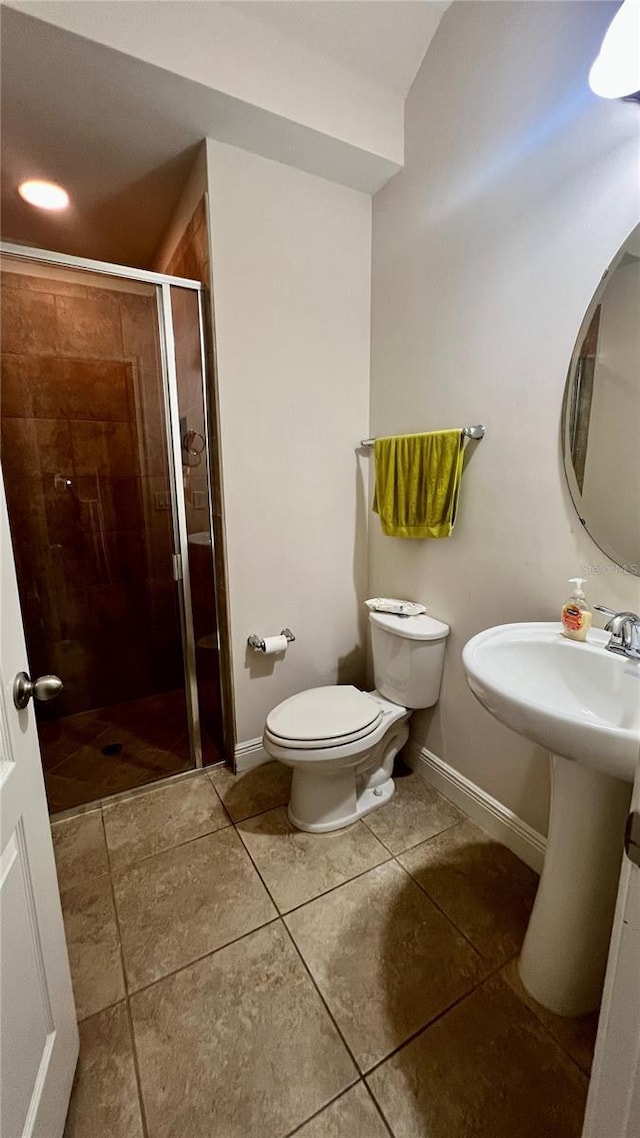 full bathroom featuring tile patterned floors, baseboards, toilet, and a stall shower