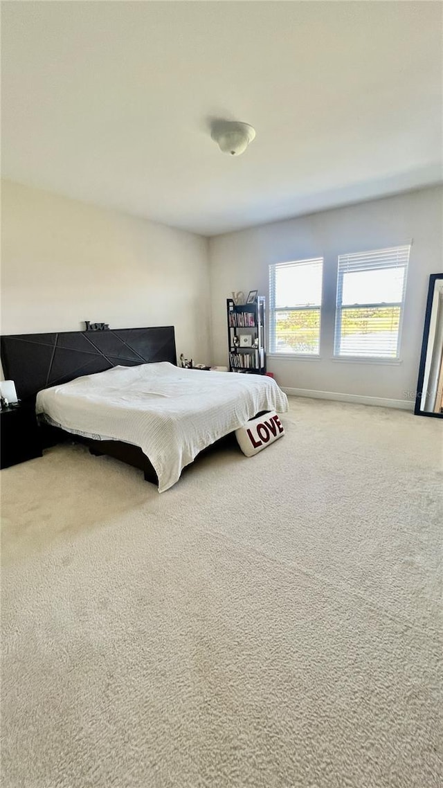 carpeted bedroom featuring baseboards