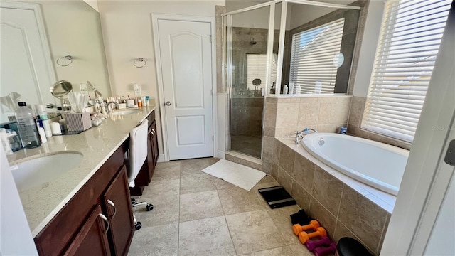 full bath featuring a shower stall, a garden tub, double vanity, tile patterned floors, and a sink