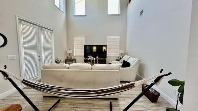 living room featuring visible vents, baseboards, and wood finish floors