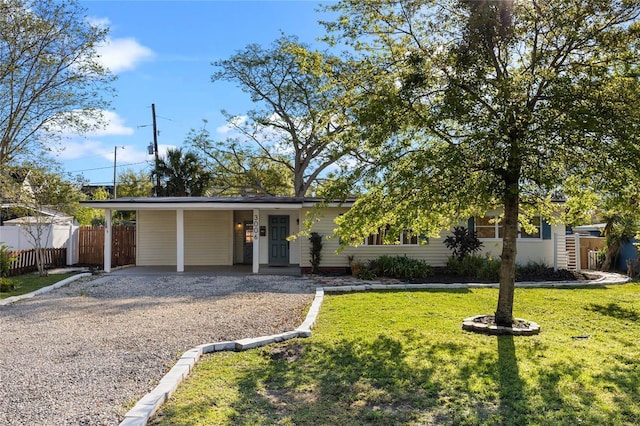 view of front of property featuring a carport, fence, a front lawn, and driveway