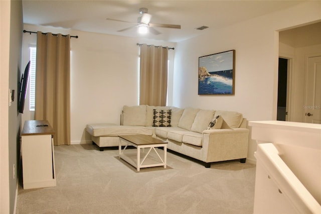 living room with visible vents, baseboards, light colored carpet, and a ceiling fan