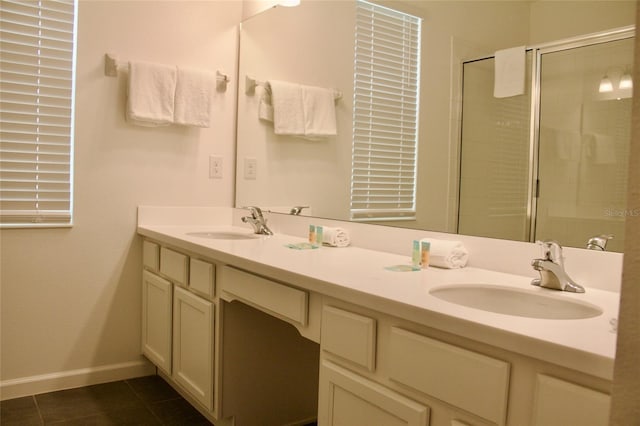 full bath with tile patterned flooring, tiled shower, and a sink