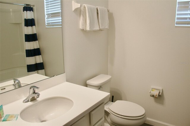 bathroom featuring vanity, toilet, and a shower with shower curtain