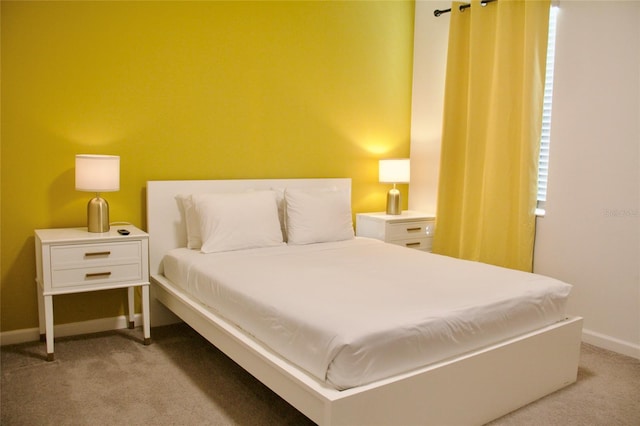 bedroom featuring light colored carpet and baseboards