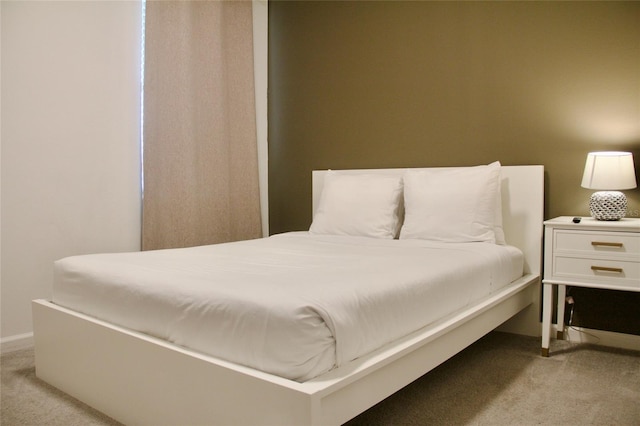 bedroom featuring baseboards and light colored carpet