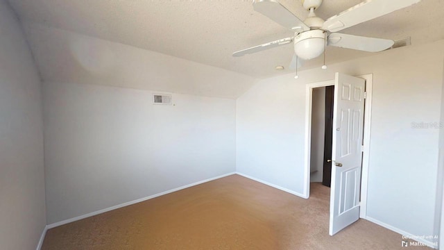 carpeted spare room featuring visible vents, baseboards, ceiling fan, and vaulted ceiling