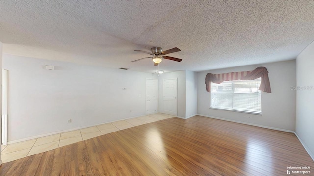 empty room featuring a textured ceiling, wood finished floors, and ceiling fan