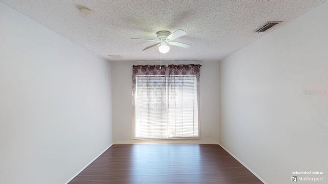 empty room with plenty of natural light, wood finished floors, visible vents, and ceiling fan