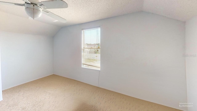 bonus room featuring lofted ceiling, a textured ceiling, carpet floors, and a ceiling fan