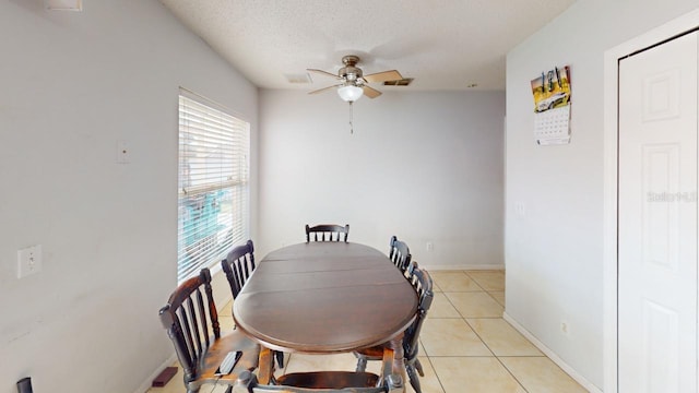 dining area with visible vents, baseboards, ceiling fan, light tile patterned flooring, and a textured ceiling