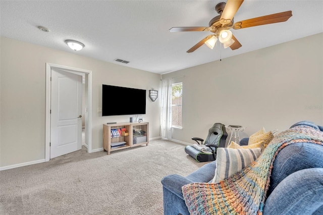 living room with visible vents, a textured ceiling, carpet floors, baseboards, and ceiling fan