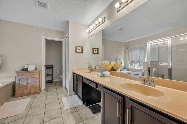 bathroom featuring visible vents, a sink, tile patterned flooring, a shower stall, and toilet