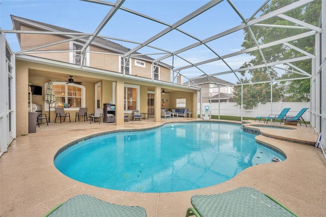 view of pool with a pool with connected hot tub, a patio, fence, glass enclosure, and ceiling fan