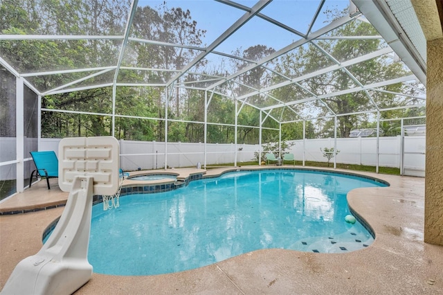 view of swimming pool featuring a lanai, a patio, a pool with connected hot tub, and a fenced backyard