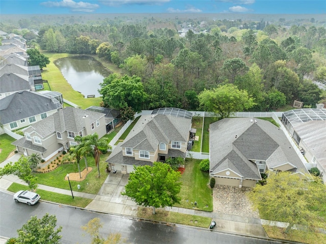 drone / aerial view with a residential view, a view of trees, and a water view