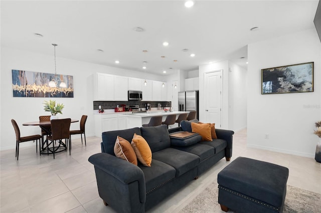 living room with light tile patterned floors, a notable chandelier, recessed lighting, and baseboards