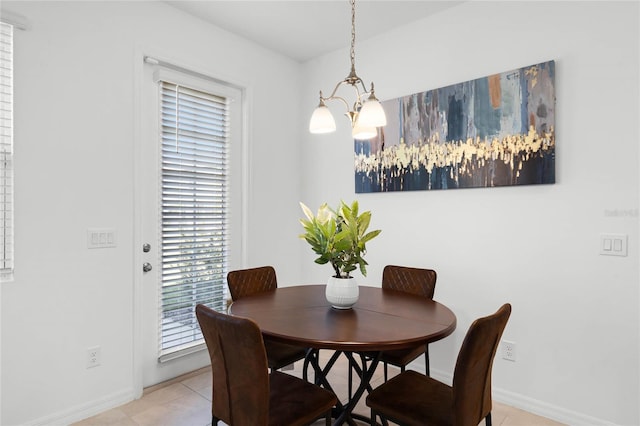 dining room featuring baseboards, a chandelier, and light tile patterned flooring