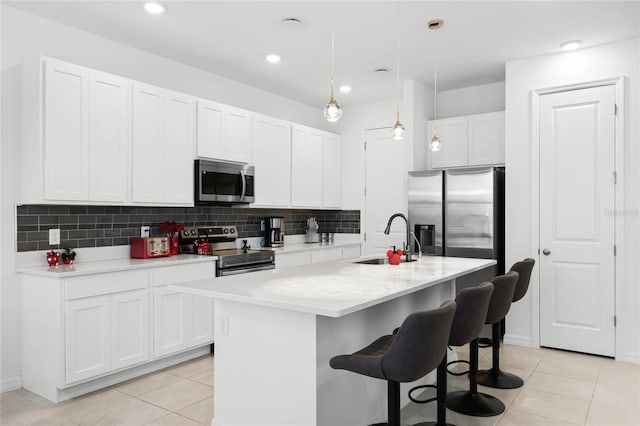 kitchen featuring decorative backsplash, white cabinetry, stainless steel appliances, and a sink