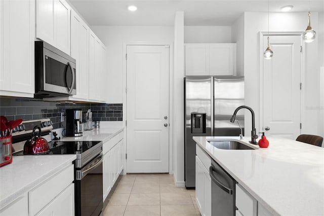 kitchen with a sink, backsplash, stainless steel appliances, white cabinets, and light countertops