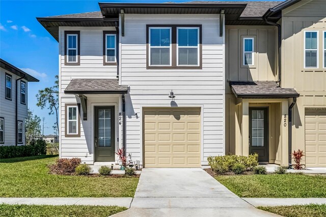824 Longboat Dr, Davenport, FL 33896 - townhome / multi-family property with a garage, driveway, board and batten siding, roof with shingles, and a front yard