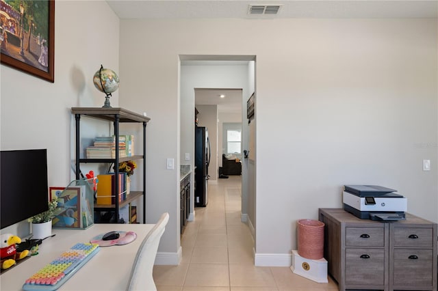 home office with light tile patterned flooring, baseboards, and visible vents