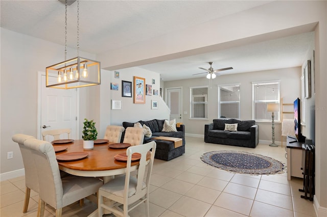 dining room with light tile patterned floors, a ceiling fan, and baseboards