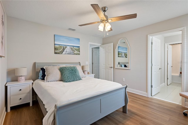 bedroom featuring visible vents, ceiling fan, baseboards, and wood finished floors