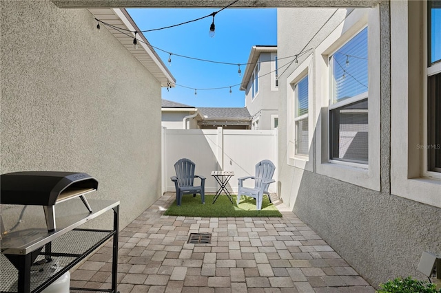 view of patio featuring visible vents and fence